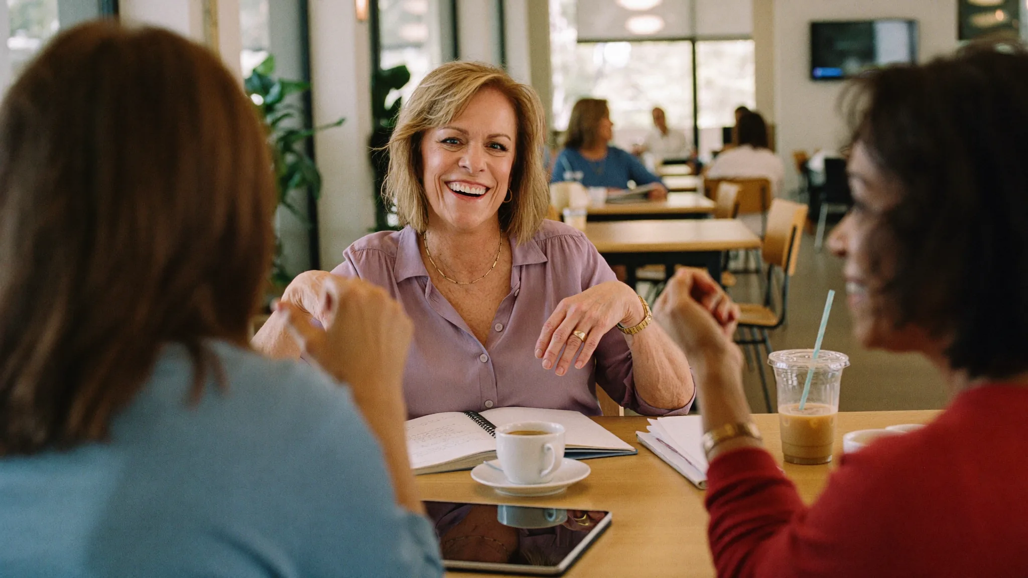 Jill Prescott laughing with coaching clients over coffee